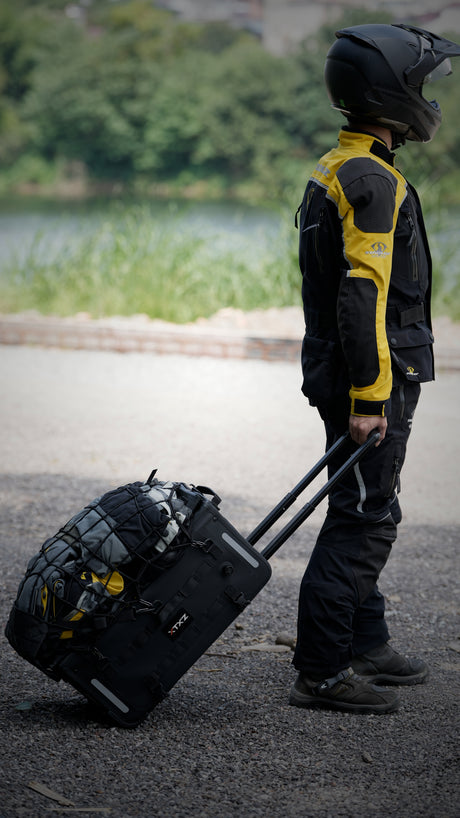 Motociclista rodando el bolso trasero XTXZ Expedition Mobility 42L con el mango extendido
